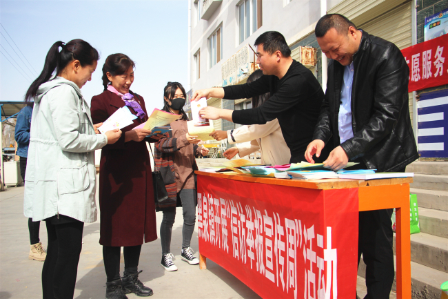 图为高台县黑泉镇纪委利用赶集日向农户宣传信访举报相关知识和发放《信访举报指南》.jpg
