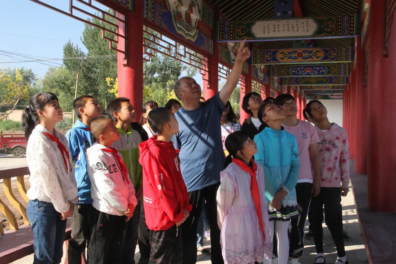 高台县宣化镇清廉家风馆，村民王大爷为孩子们讲解家风故事。.jpg