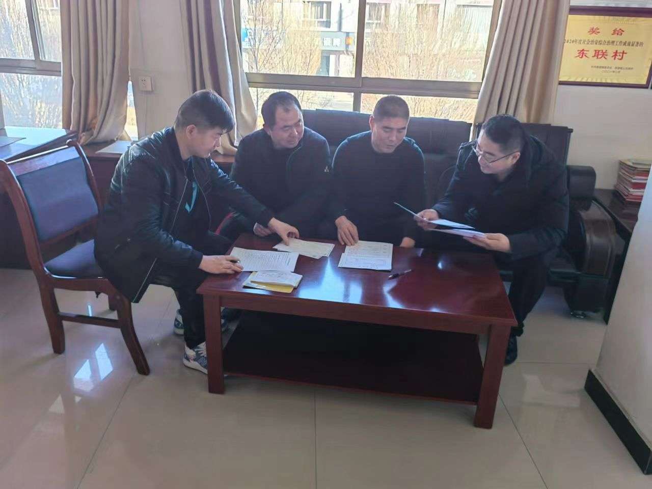 图为巷道镇东联村监委会主任胡万福正和监委会成员对本月村上财务进行审查.jpg