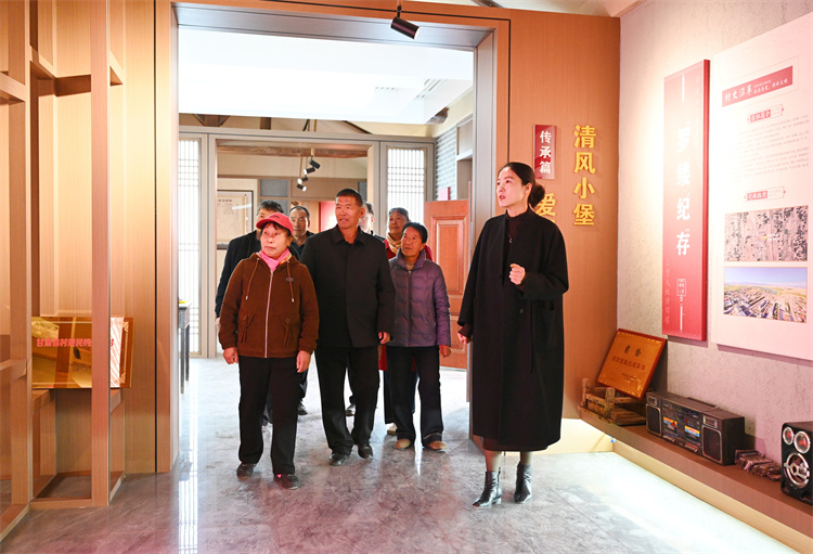 张掖市民乐县纪委监委深入挖掘三堡镇三堡村本土优秀家风家训和历史廉洁故事，打造“清风小堡”，教育引导村组干部规范用权。图为纪检监察干部引导党员干部群众在清风小堡开展参观学习2.王梦婷 摄_副本.jpg